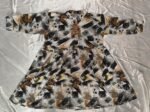 Woman wearing black, mustard and cream abstract printed flared midi dress with three-quarter sleeves.